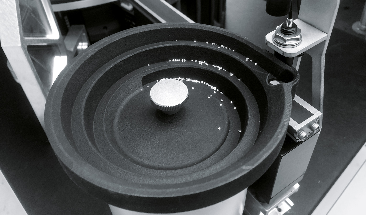 A vibrating spiral conveyor transports diamonds to the optical sieve and aligns them on their flat side. In this way, the conveyor prevents the stones from being damaged during tipping.