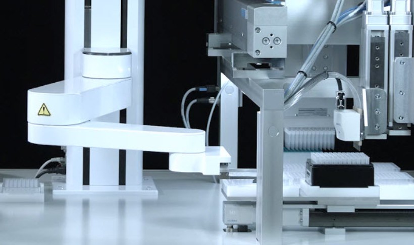 Robot with gripper fingers transfers the microplate from module to module