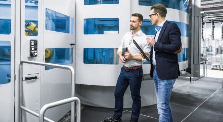 Männer diskutieren in Produktionshalle