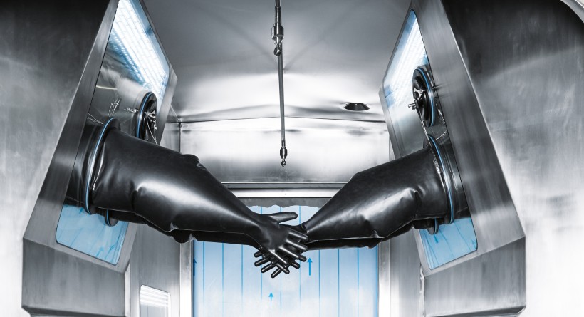 Isolator with rubber gloves for opening the vessels