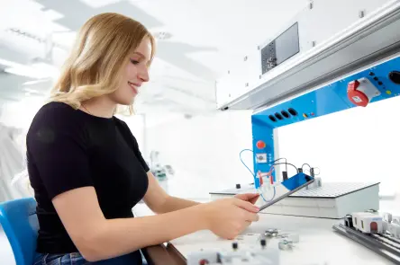 Student kontroluje údaje na tabletu při práci na elektrotechnické sestavě.