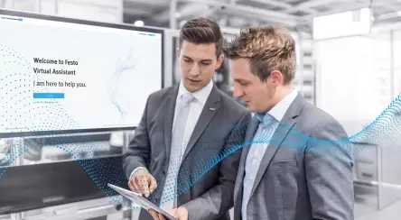 A Festo expert explains the benefits of the Virtual Assistant to a customer on the Festo booth at a fair.
