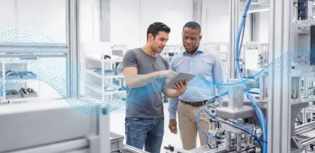 Two engineers on the shop floor use the Virtual Assistant on a tablet to solve a technical issue.