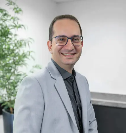 Daniel Lopes, dyrektor i założyciel firmy HYTRON, stoi wewnątrz budynku i uśmiecha się do kamery.