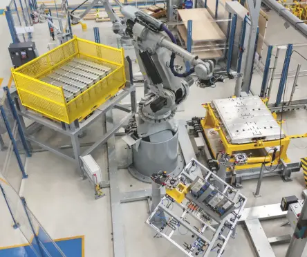 大型の多関節産業用ロボットアームを中心とした産業用オートメーションシステム。