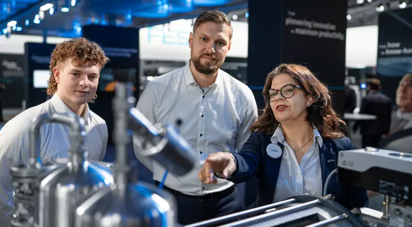 A Festo expert explains an automation solution to visitors of the Festo booth at Hannover Messe.