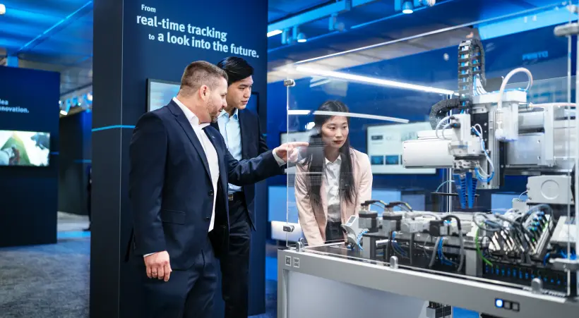 A Festo colleague explains seamless automation to two customers on the Hannover Messe.