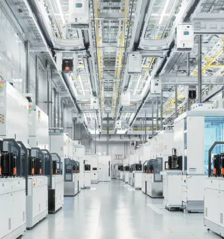 Línea de producción de una fábrica de semiconductores con equipos de proceso y FOUPs en un sistema de transporte suspendido.