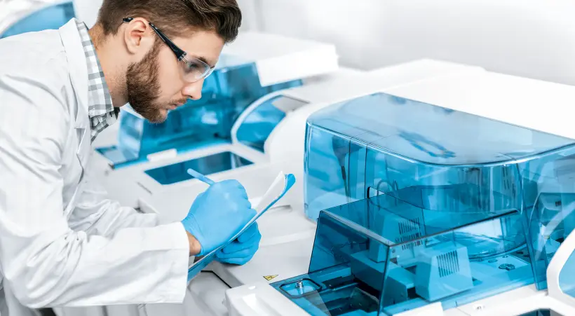 An medical employee in a laboratory checks the results of a life tech application.