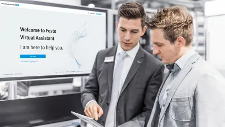 A Festo expert explains the benefits of the Virtual Assistant to a customer on the Festo booth at a fair.