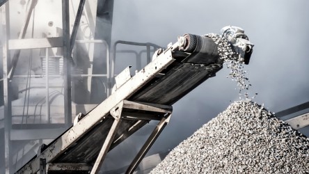 Close-up of a conveyor belt throwing gravel on a heap