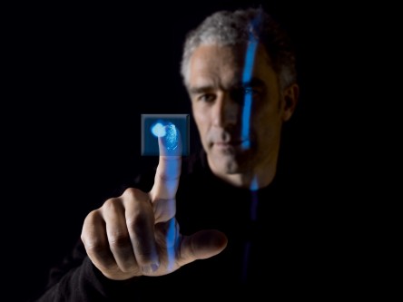 Hombre utilizando tecnología táctil con reconocimiento de huella digital e interfaz digital futurista.