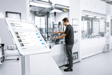 une personne devant une logne de production automatisée pour se former à la programmation d'automates Siemens, Schneider et Rockwell