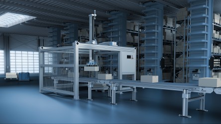 Uma representação digital de um sistema de automação intralogística em um armazém. A imagem mostra um braço robótico sobre trilhos transportando caixas em uma sala com prateleiras altas cheias de outras caixas. O ambiente tem um tom azul frio, sugerindo uma atmosfera industrial moderna e eficiente.