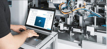 hombre escribiendo en la computadora y la suite de automatización festo aparece en la pantalla